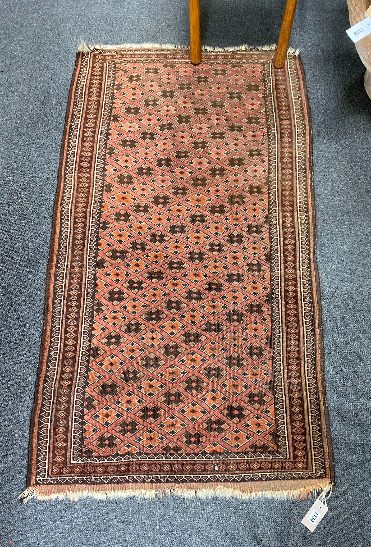 A Belouch red ground rug, 142 x 80cm